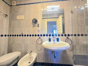 Un baño con lavabo, inodoro y espejo. en Casa Gentile, en Marina Grande 12 fotos más