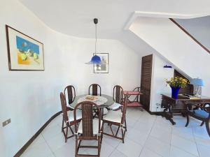 Un comedor con una mesa y sillas y un piano. en Casa Gentile, en Marina Grande