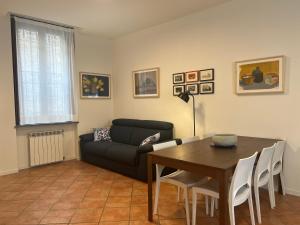 a living room with a table and a couch at Appartamento Il glicine Cremona Centro in Cremona