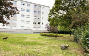 a park with two benches in front of a building at Bed and Breakfast Nantes au calme proche aéroport, gare et centre-ville in Saint-Sébastien-sur-Loire