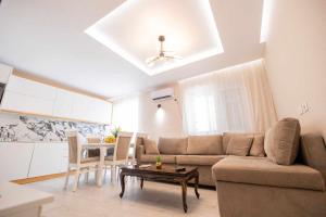 a living room with a couch and a table at Zoto Luxury Apartment in Himare
