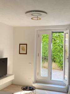 - un salon avec une télévision et une porte coulissante en verre dans l'établissement Casa Cotone 9, à Marciana Marina