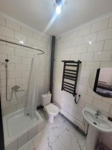 a white bathroom with a toilet and a sink at Антарес Отель in Shemonaīkha