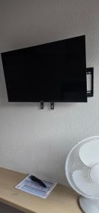 a flat screen tv hanging on a wall at Sleep and Go - Budget in Interlaken