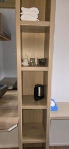 a cupboard in a kitchen with a shelf with a pot and pans at Sleep and Go - Budget in Interlaken