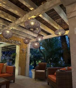 Un patio con sillas y candelabros en un porche. en Villa Gadja Bali, en Jimbaran