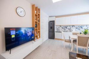a living room with a tv and a dining room at Zoto Luxury Apartment in Himare
