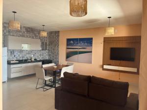 a kitchen and a living room with a couch and a table at Casa Lago Santo Amaro in Queimada +2 photos