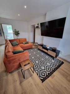 a living room with a couch and a flat screen tv at Appartement Rome Charme et Confort in Flers-en-Escribeus