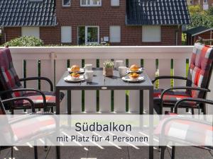 une table avec des assiettes de nourriture sur une terrasse dans l'établissement Lotsenglück Fehmarn, Nähe Hafen Burgstaaken, perfekt für Familien & Paare, à Burg