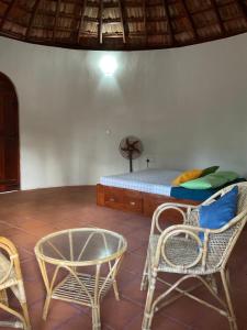 a room with a bed and chairs and a table at Banyan Beach Cottage SRI LANKA in Kalapu