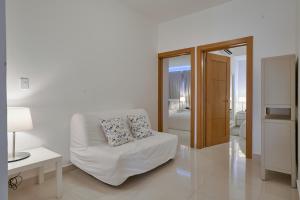 Una sala de estar blanca con un sofá y una mesa. en Apartments in La Julia 1 and 2 Bedrooms, en Santo Domingo 27 fotos más