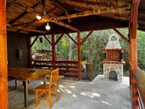 a patio with a wooden table and a fireplace at Casa cu pădure in Breaza