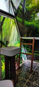 a bathroom with a sink and a painting of a forest at cinnamon avenue cabanas in Negombo