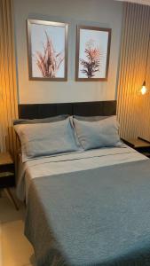 a bedroom with a bed with three pictures on the wall at Casa Temporada Waldemar Damasceno - Beira Rio com piscina in Piranhas