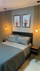 a bedroom with a bed with three pictures on the wall at Casa Temporada Waldemar Damasceno - Beira Rio com piscina in Piranhas
