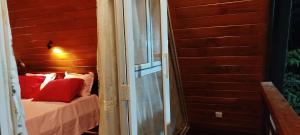 a bed with red pillows sitting next to a door at cinnamon avenue cabanas in Negombo