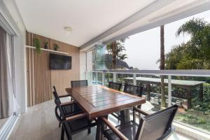 a dining room with a table and chairs on a balcony at Varandas do Atlântico 101A - Excelente apartamento em condomínio de luxo a beira mar - Piscina climatizada - Academia - (Consultar serviços de roupas de cama e banho) in Bombinhas