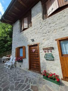 un edificio con puerta de madera, mesa y sillas en Holiday home in Tiarno di Sotto 23505, en Tiarno di Sotto