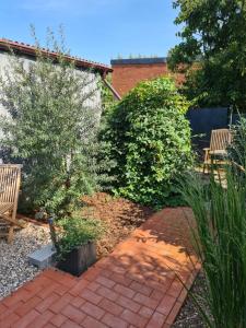 a garden with two benches and a brick path at Gästehaus Wolkenlos in Fehmarn