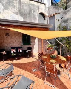 a patio with a table and chairs and a yellow umbrella at Isabel’s house in Vietri sul Mare