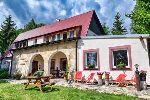 杜什尼基-兹德鲁伊Zbójnicka Chata的一座红色屋顶和椅子的房子