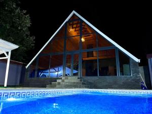 a house with a swimming pool at night at Blue Pool Paradise in Gabala