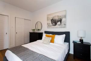 a bedroom with a large bed and a picture of an elephant at Sleek Condo in the Heart of Little Italy by Den Stays in Montréal