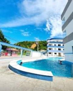 una piscina di fronte a un edificio di Apt 202 Frente para o Mar e Piscina Village das Ondas a Piúma