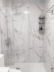 a bathroom with a shower with white marble walls at Moderno Apartamento en Peñíscola Centro, cerca de la Playa y el Castillo Papa Luna in Peñíscola +21 photos