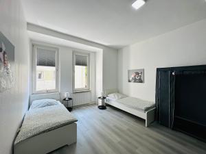 a white room with two beds and two windows at FeWo for max 6 Guests near Hagen-City in Hagen +11 photos