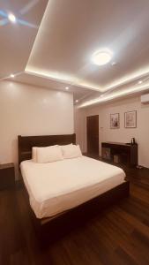 a bedroom with a large white bed in a room at Camilles Pension House in Puerto Princesa City