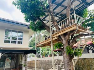 a tree house with a deck on top of it at Camilles Pension House in Puerto Princesa City