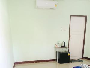 een kamer met een witte muur en een koelkast bij คอปเตอร์ Resort in Ban Khlot