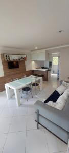 un soggiorno con un tavolo e un divano di Apt 202 Frente para o Mar e Piscina Village das Ondas a Piúma