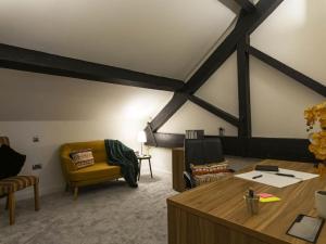 a living room with a yellow chair and a table at 5-Bedroom Luxury Duplex Penthouse in Bradford +13 photos