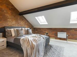 a bedroom with a bed and a brick wall at 5-Bedroom Luxury Duplex Penthouse in Bradford