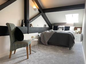 a bedroom with a bed and a chair at 5-Bedroom Luxury Duplex Penthouse in Bradford