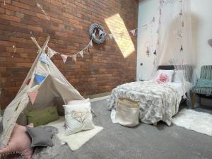 a room with a bed and a brick wall at 5-Bedroom Luxury Duplex Penthouse in Bradford