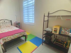 ein Schlafzimmer mit einem Bett und einem Regal mit Spielzeug in der Unterkunft Homestay Rumoh Mok in Jitra