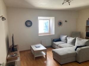 un soggiorno con un divano e un orologio a parete di Maison de village a Audelange