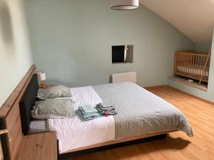 una camera con un letto con due asciugamani e una culla di Maison de village a Audelange