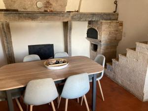 una sala da pranzo con un tavolo e un forno per la pizza di Maison de village a Audelange Altre 15 foto