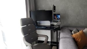a living room with a desk with a computer and a couch at BalticSky Loft Premium, Apartament K o ł o b r z e g in Kołobrzeg +40 photos
