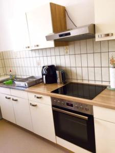 a kitchen with a sink and a stove top oven at Ferienwohnung Dinh in Uhldingen-Mühlhofen