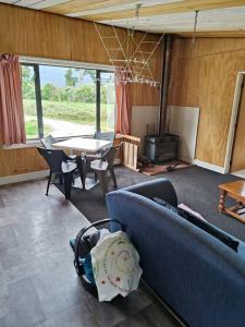 a living room with a blue couch and a table at Valley Views Haast in Haast