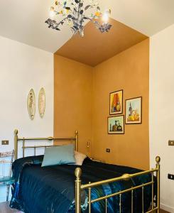 a bedroom with a bed and a chandelier at Maison Le Calle in Vallo di Nera