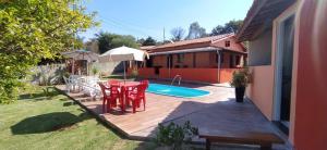 a patio with a table and chairs and a pool at Chácara do Juscelino in Monte Sião