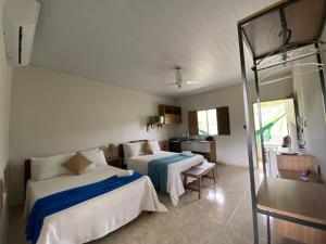 a hotel room with two beds and a kitchen at Aptos e Flats condomínio Pedra do Rodeadouro in Bonito