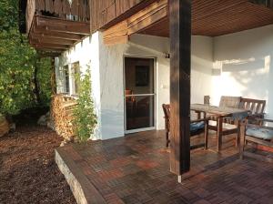 a patio with a wooden table and chairs on a house at Burgberg Schöllnstein in Iggensbach